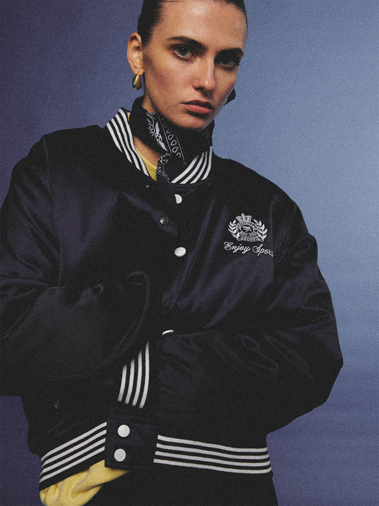Arosris midnight navy high-gloss satin padded bomber jacket featuring a bold vintage club back embroidery, styled for an effortless 90s sporty-chic varsity aesthetic.