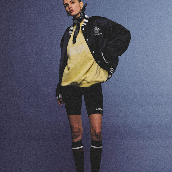Arosris midnight navy high-gloss satin padded bomber jacket featuring a bold vintage club back embroidery, styled for an effortless 90s sporty-chic varsity aesthetic.