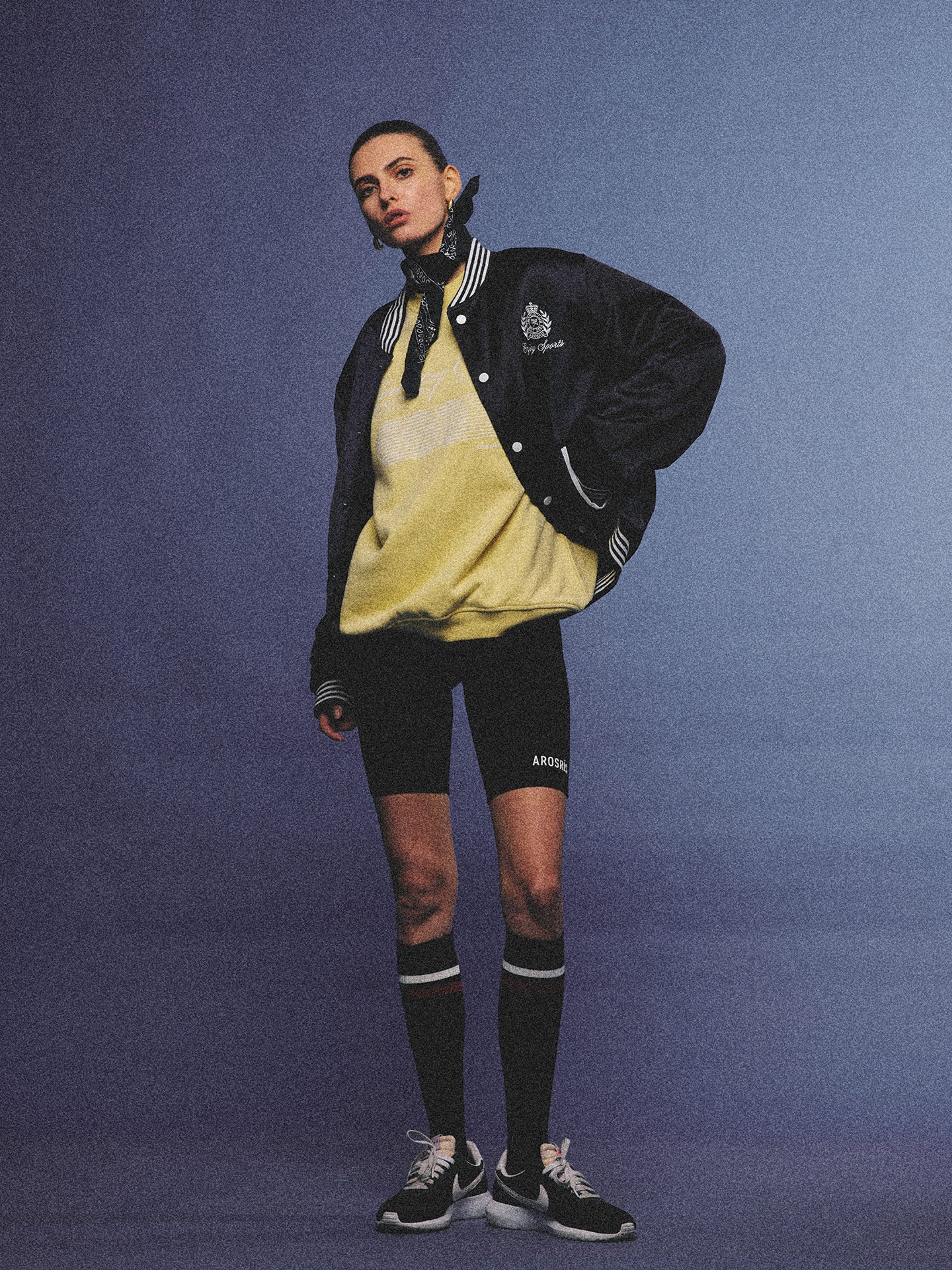Arosris midnight navy high-gloss satin padded bomber jacket featuring a bold vintage club back embroidery, styled for an effortless 90s sporty-chic varsity aesthetic.