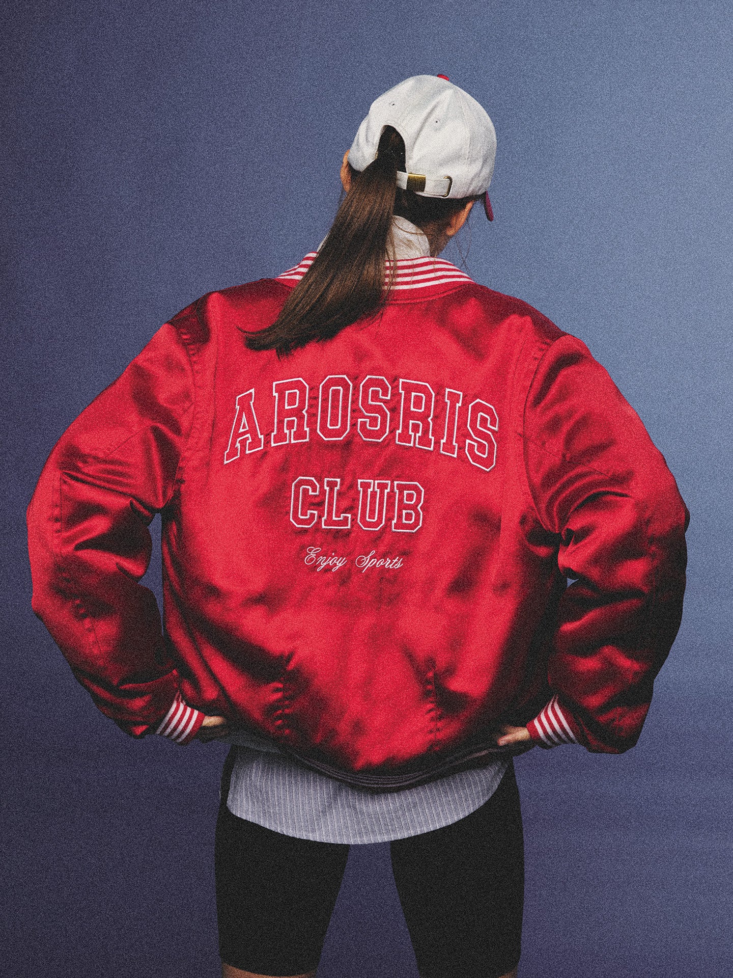 Arosris cherry red high-gloss satin padded bomber jacket featuring a bold vintage club back embroidery, styled with retro accessories for a striking 90s sporty-chic aesthetic.