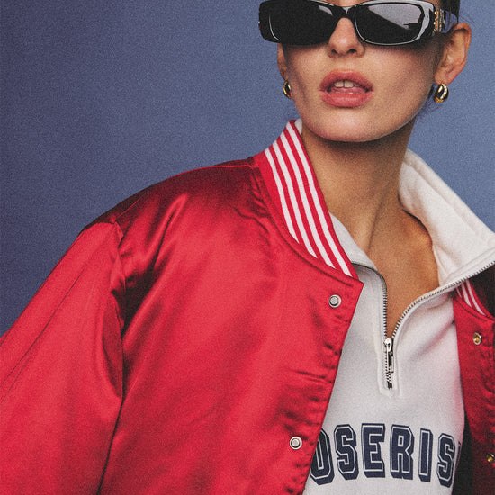 Arosris cherry red high-gloss satin padded bomber jacket featuring a bold vintage club back embroidery, styled with retro accessories for a striking 90s sporty-chic aesthetic.