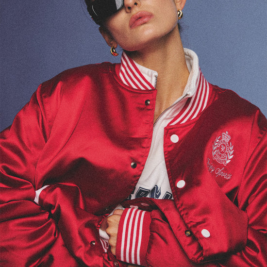 Arosris cherry red high-gloss satin padded bomber jacket featuring a bold vintage club back embroidery, styled with retro accessories for a striking 90s sporty-chic aesthetic.