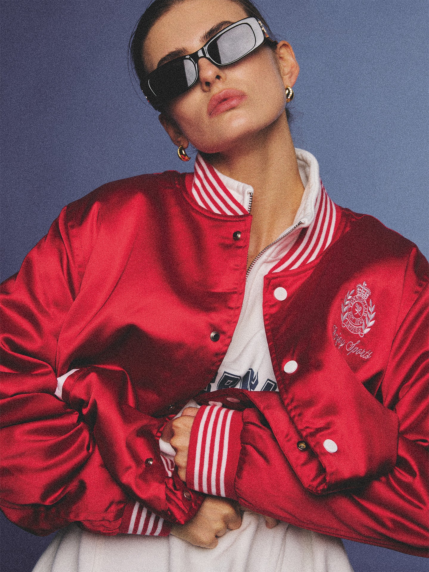Arosris cherry red high-gloss satin padded bomber jacket featuring a bold vintage club back embroidery, styled with retro accessories for a striking 90s sporty-chic aesthetic.