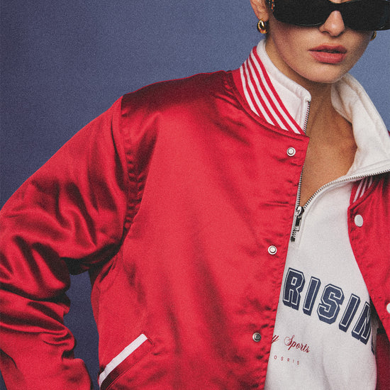 Arosris cherry red high-gloss satin padded bomber jacket featuring a bold vintage club back embroidery, styled with retro accessories for a striking 90s sporty-chic aesthetic.