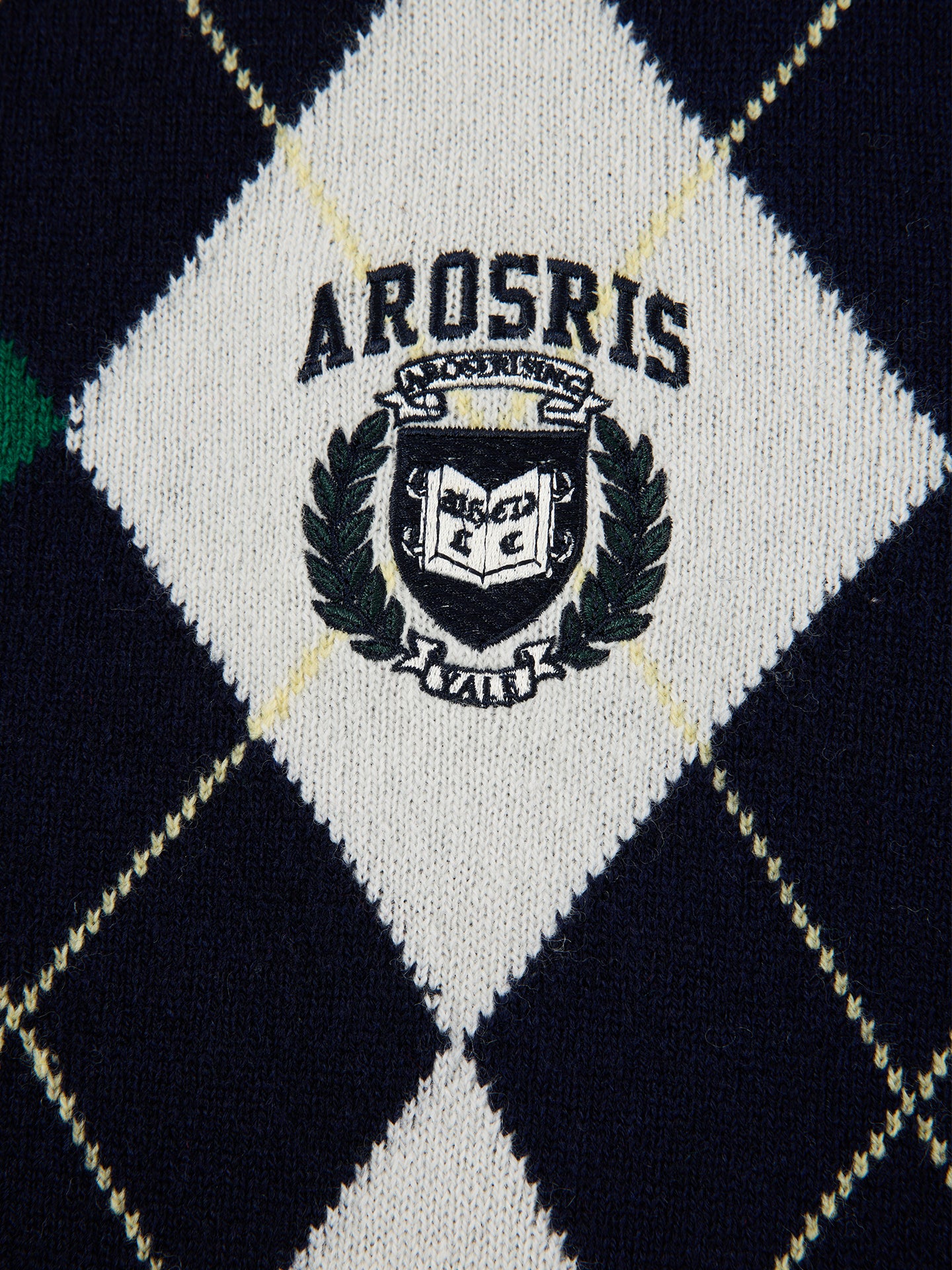 Part of The Ivy Archive. Master the 90s preppy aesthetic with our 100% sheep wool argyle polo sweater, featuring a classic collegiate pattern and crest embroidery.