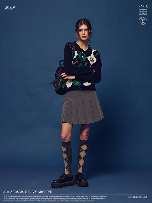 Part of The Ivy Archive. Master the 90s preppy aesthetic with our 100% sheep wool argyle polo sweater, featuring a classic collegiate pattern and crest embroidery.