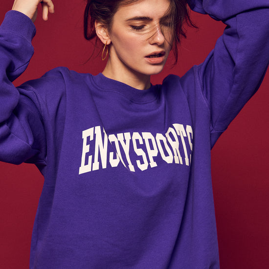 Arosris Ivy Archive Enjoy Sports crewneck sweatshirt in purple, styled with white shorts, sneakers, and a basketball for an effortless 90s off-duty street style look.