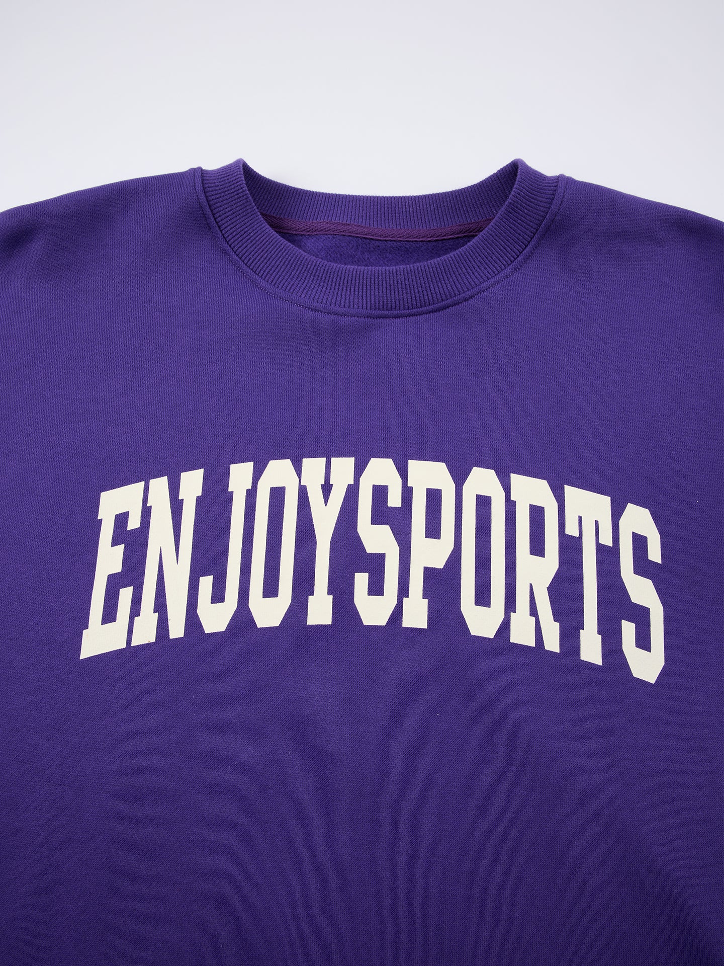 Arosris Ivy Archive Enjoy Sports crewneck sweatshirt in purple, showing the classic crew neckline and the vintage collegiate arch print.