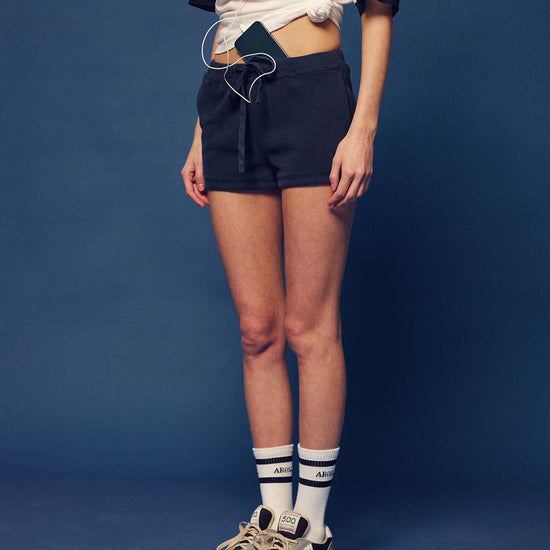 Arosris Ivy Archive high-rise varsity shorts featuring a 3-inch inseam and thick drawstring, elegantly styled on a model for an effortless 90s collegiate and sporty rich aesthetic.