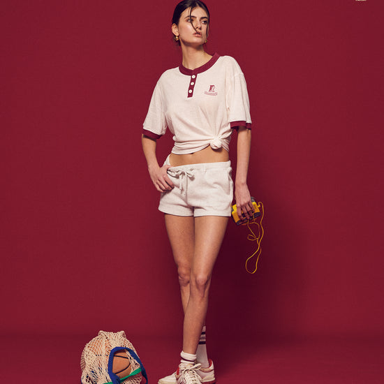 Arosris Ivy Archive high-rise varsity shorts featuring a 3-inch inseam and thick drawstring, elegantly styled on a model for an effortless 90s collegiate and sporty rich aesthetic.
