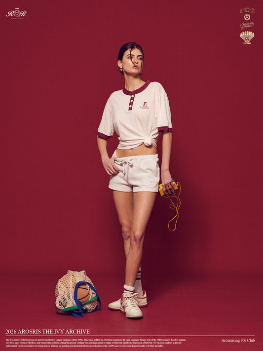 Arosris Ivy Archive high-rise varsity shorts featuring a 3-inch inseam and thick drawstring, elegantly styled on a model for an effortless 90s collegiate and sporty rich aesthetic.