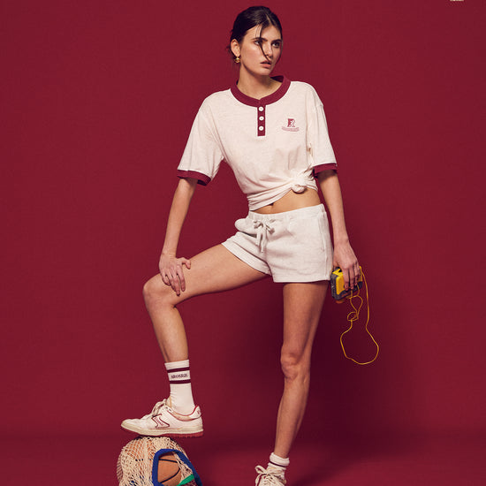 Arosris Ivy Archive high-rise varsity shorts featuring a 3-inch inseam and thick drawstring, elegantly styled on a model for an effortless 90s collegiate and sporty rich aesthetic.