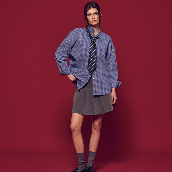 Arosris Ivy Archive pleated mini skirt in grey, styled with classic collegiate knitwear and shirting for an effortless 90s preppy look.