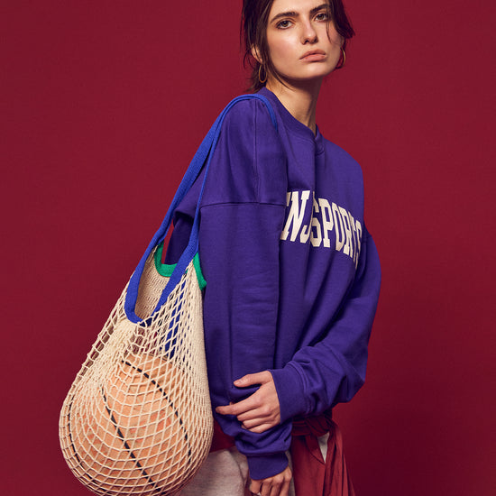 Arosris Ivy Archive Enjoy Sports crewneck sweatshirt in purple, styled with white shorts, sneakers, and a basketball for an effortless 90s off-duty street style look.