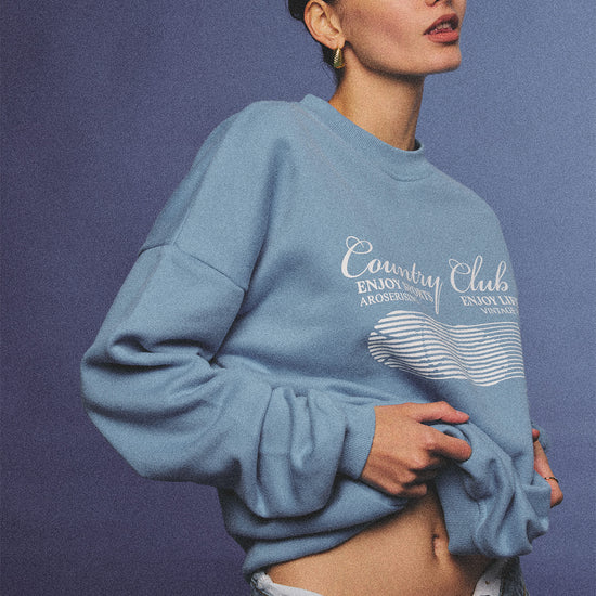 Arosris vintage white lightweight graphic training top crafted from breathable semi-sheer fabric, featuring a retro tennis sport graphic, elegantly styled for an effortless 90s sporty rich and off-duty athletic aesthetic.