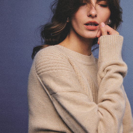 Arosris greige modern chic cashmere chunky knit sweater elegantly styled on a model over a crisp collared shirt, channeling an old money and quiet luxury aesthetic.
