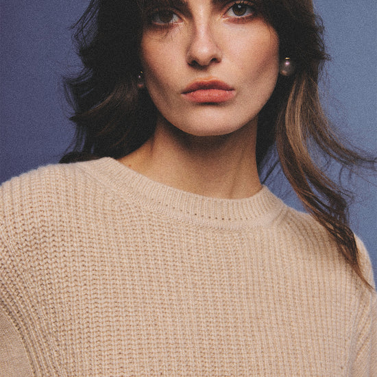Arosris greige modern chic cashmere chunky knit sweater elegantly styled on a model over a crisp collared shirt, channeling an old money and quiet luxury aesthetic.