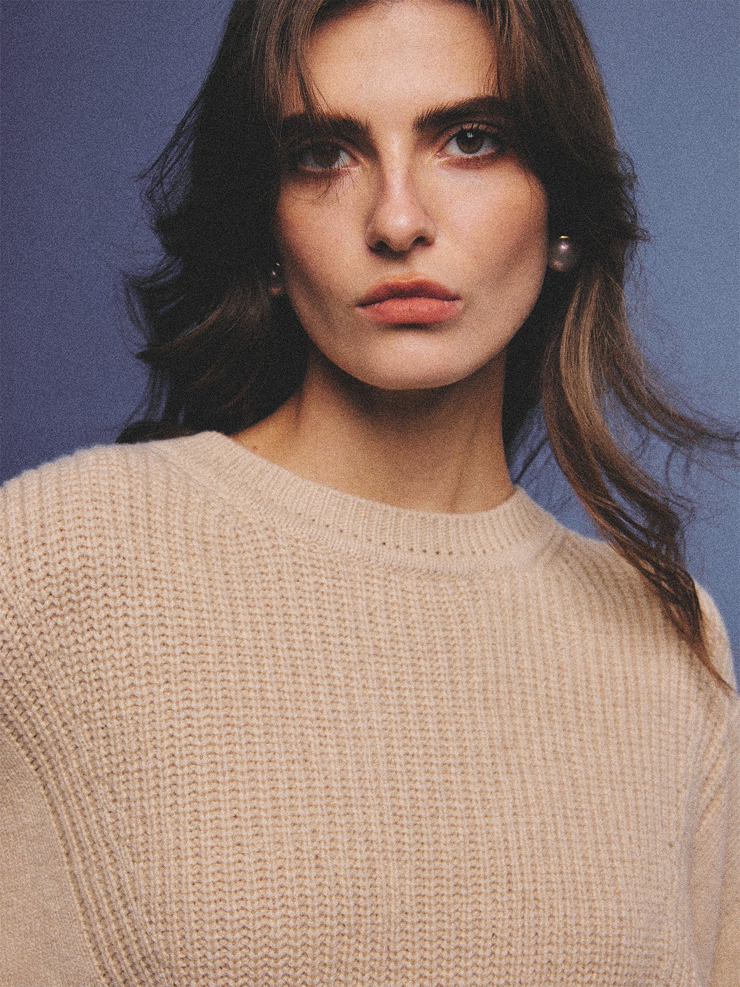Arosris greige modern chic cashmere chunky knit sweater elegantly styled on a model over a crisp collared shirt, channeling an old money and quiet luxury aesthetic.