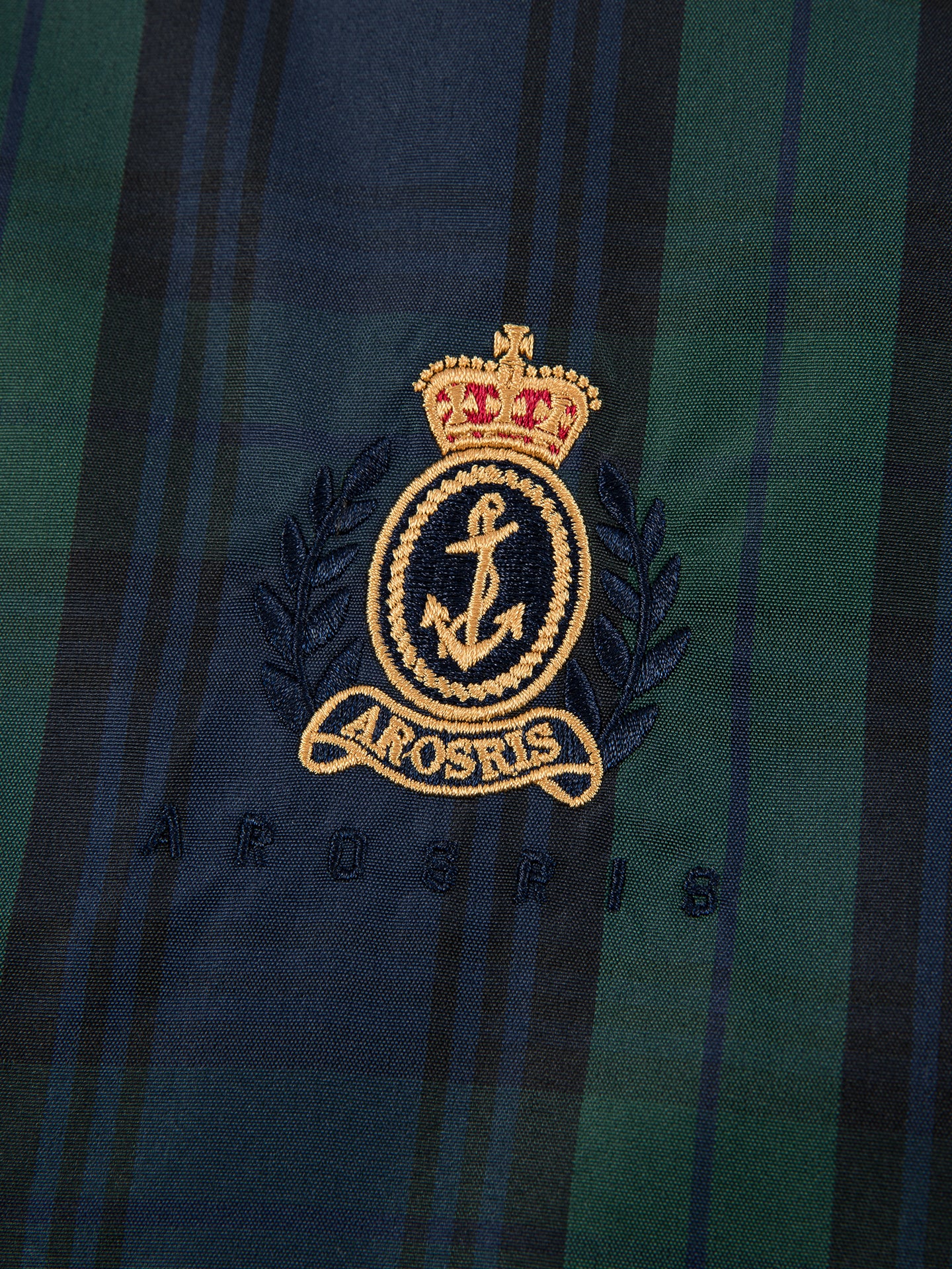 Arosris offshore Harrington jacket in classic navy and green Blackwatch tartan, styled with wide-leg jeans for a 90s vintage nautical look.