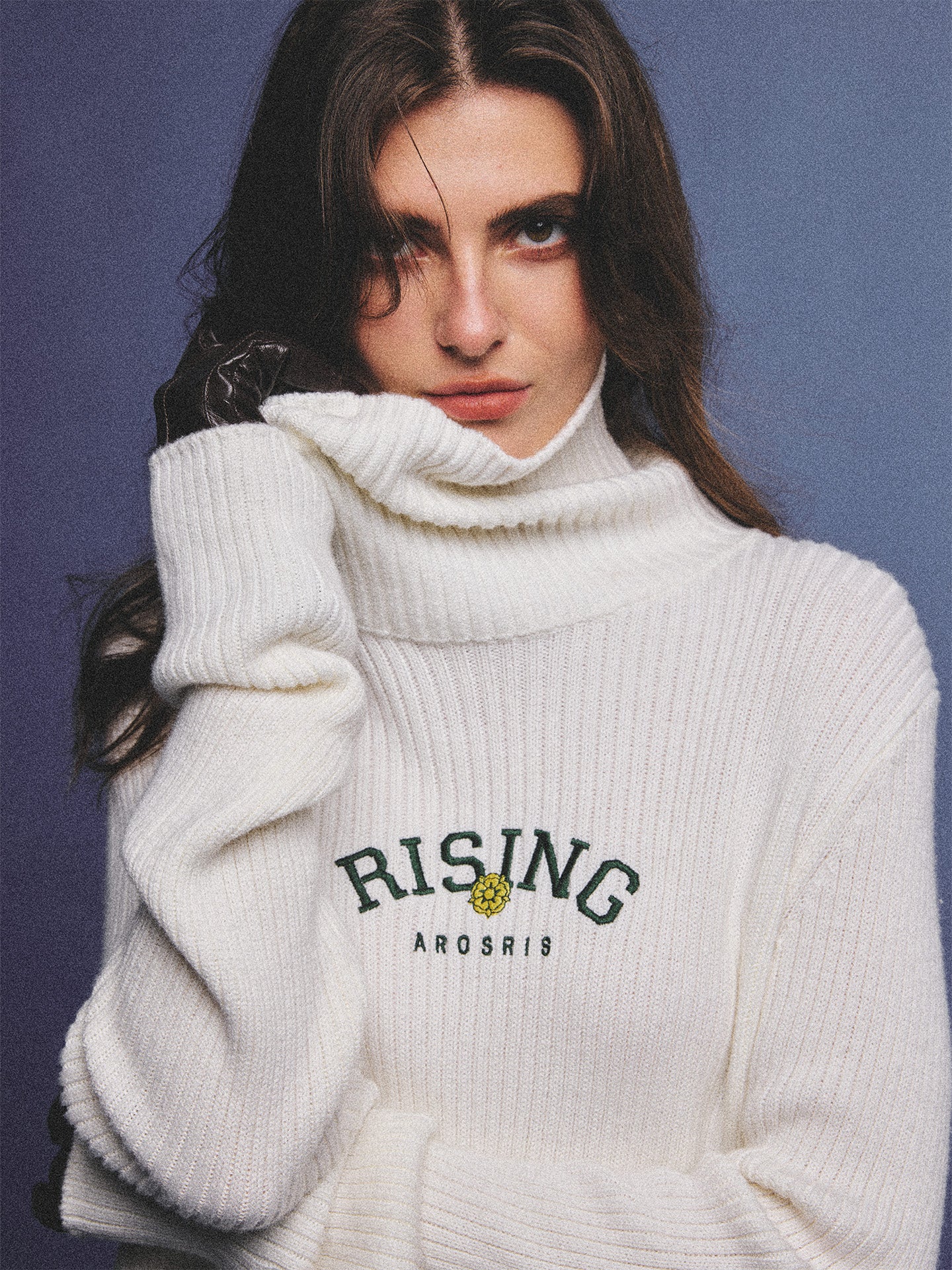Arosris classic modern white ribbed wool blend turtleneck featuring a vintage 'RISING' floral embroidery, elegantly styled on a model as an effortless 90s preppy foundational layering piece.