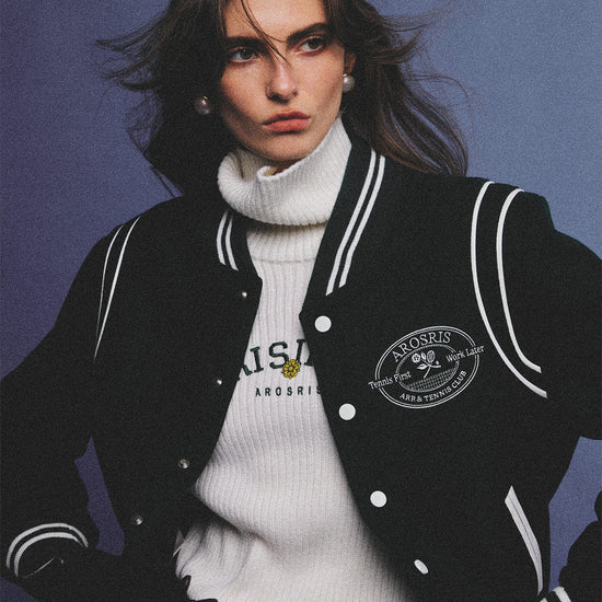 Arosris classic modern white ribbed wool blend turtleneck featuring a vintage 'RISING' floral embroidery, elegantly styled on a model as an effortless 90s preppy foundational layering piece.
