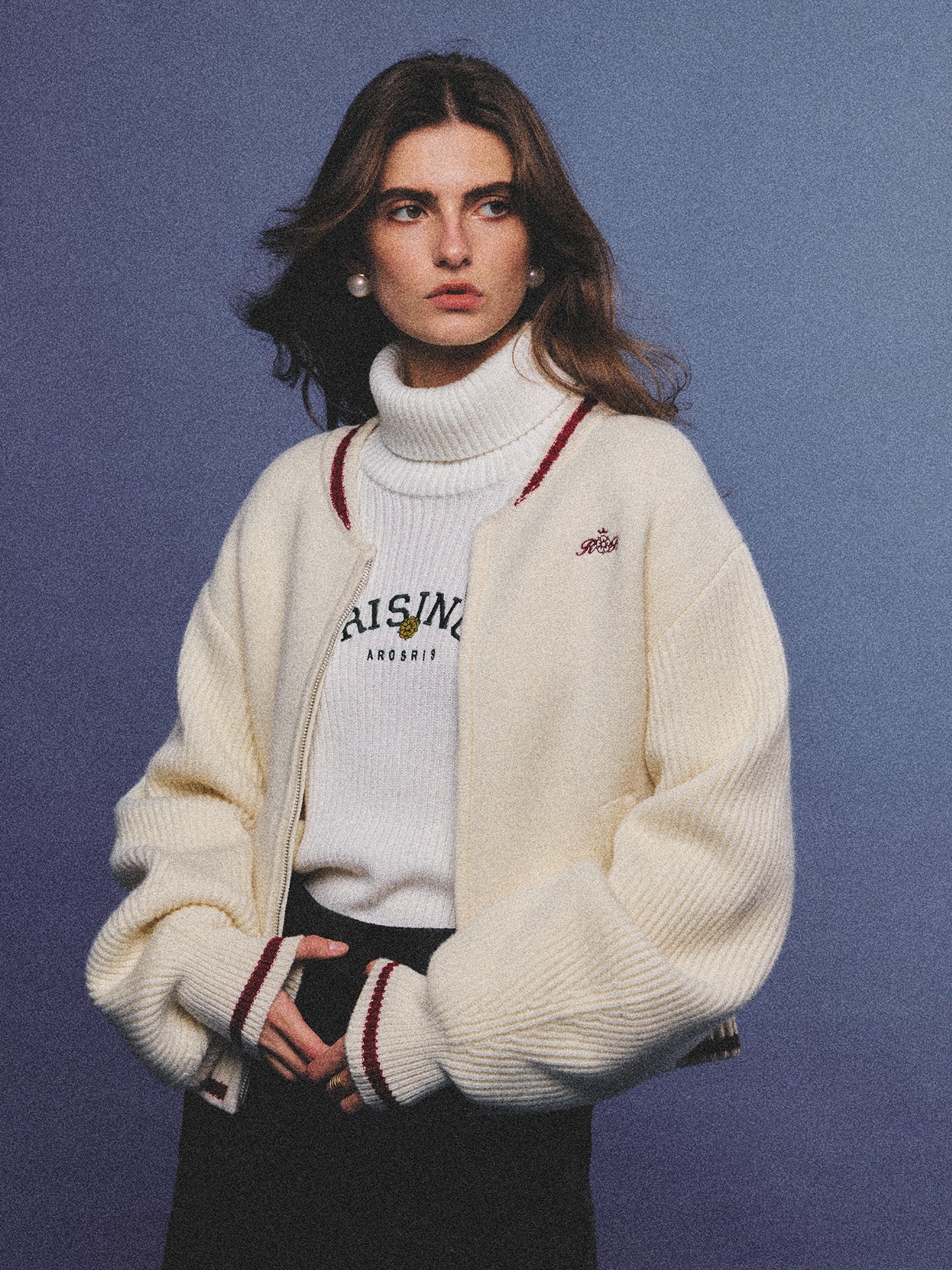 Arosris classic modern white ribbed wool blend turtleneck featuring a vintage 'RISING' floral embroidery, elegantly styled on a model as an effortless 90s preppy foundational layering piece.