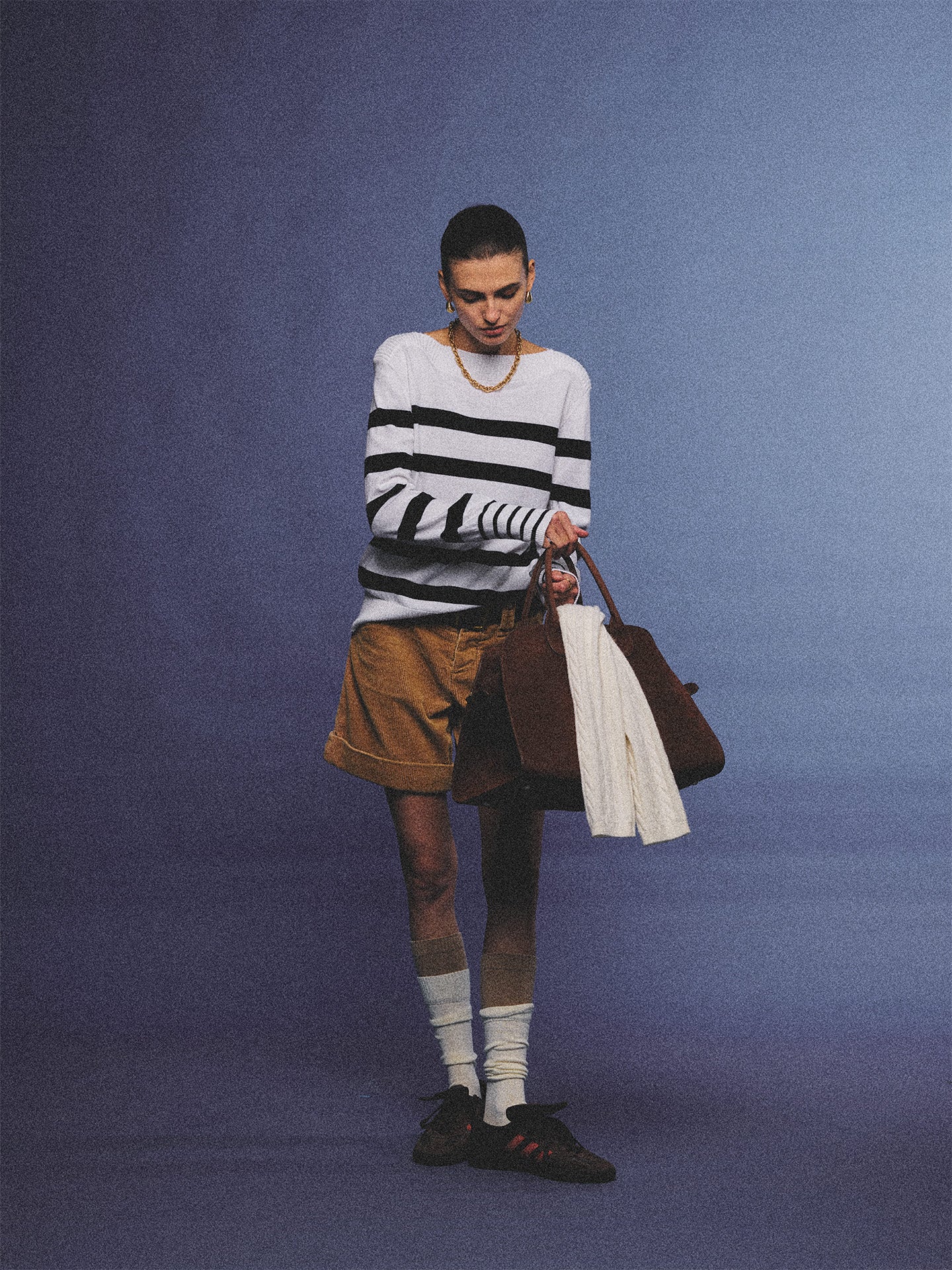 Arosris Riviera navy striped boat neck sweater elegantly styled on a model with corduroy shorts and vintage accessories, capturing an effortless 90s old money coastal resort aesthetic.