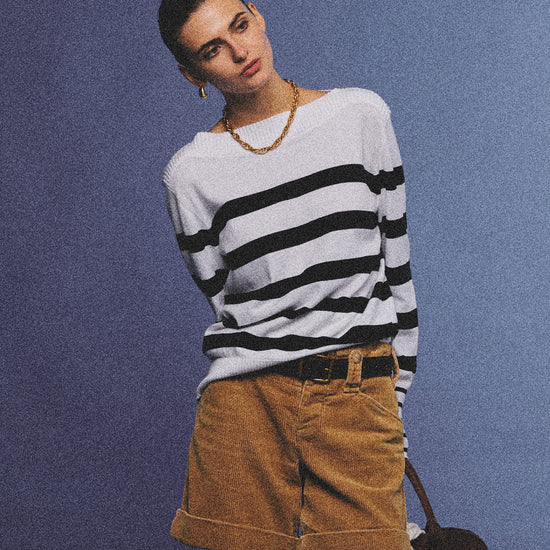 Arosris Riviera navy striped boat neck sweater elegantly styled on a model with corduroy shorts and vintage accessories, capturing an effortless 90s old money coastal resort aesthetic.