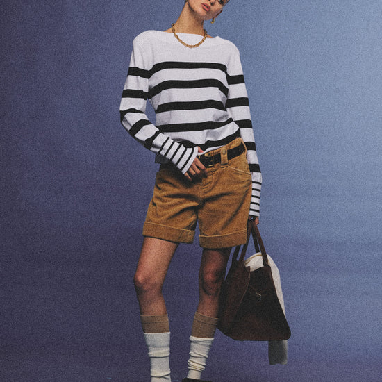 Arosris Riviera navy striped boat neck sweater elegantly styled on a model with corduroy shorts and vintage accessories, capturing an effortless 90s old money coastal resort aesthetic.