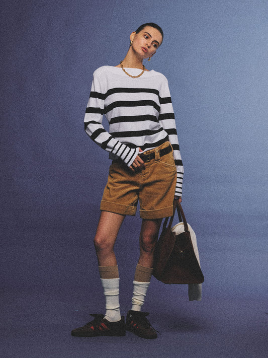 Arosris Riviera navy striped boat neck sweater elegantly styled on a model with corduroy shorts and vintage accessories, capturing an effortless 90s old money coastal resort aesthetic.