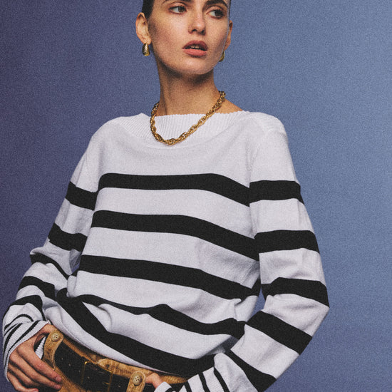 Arosris Riviera navy striped boat neck sweater elegantly styled on a model with corduroy shorts and vintage accessories, capturing an effortless 90s old money coastal resort aesthetic.