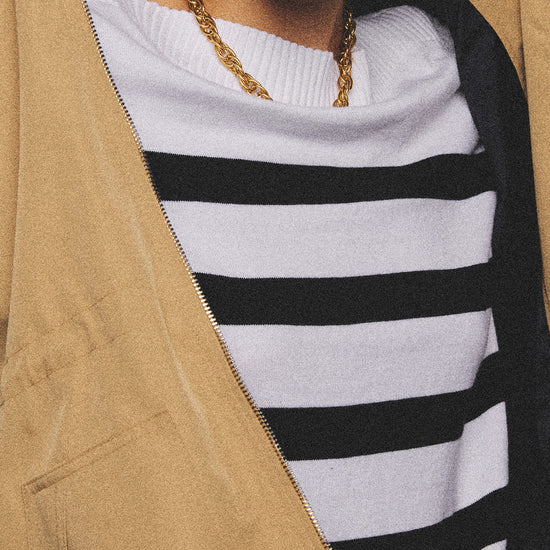 Arosris Riviera navy striped boat neck sweater elegantly styled on a model with corduroy shorts and vintage accessories, capturing an effortless 90s old money coastal resort aesthetic.