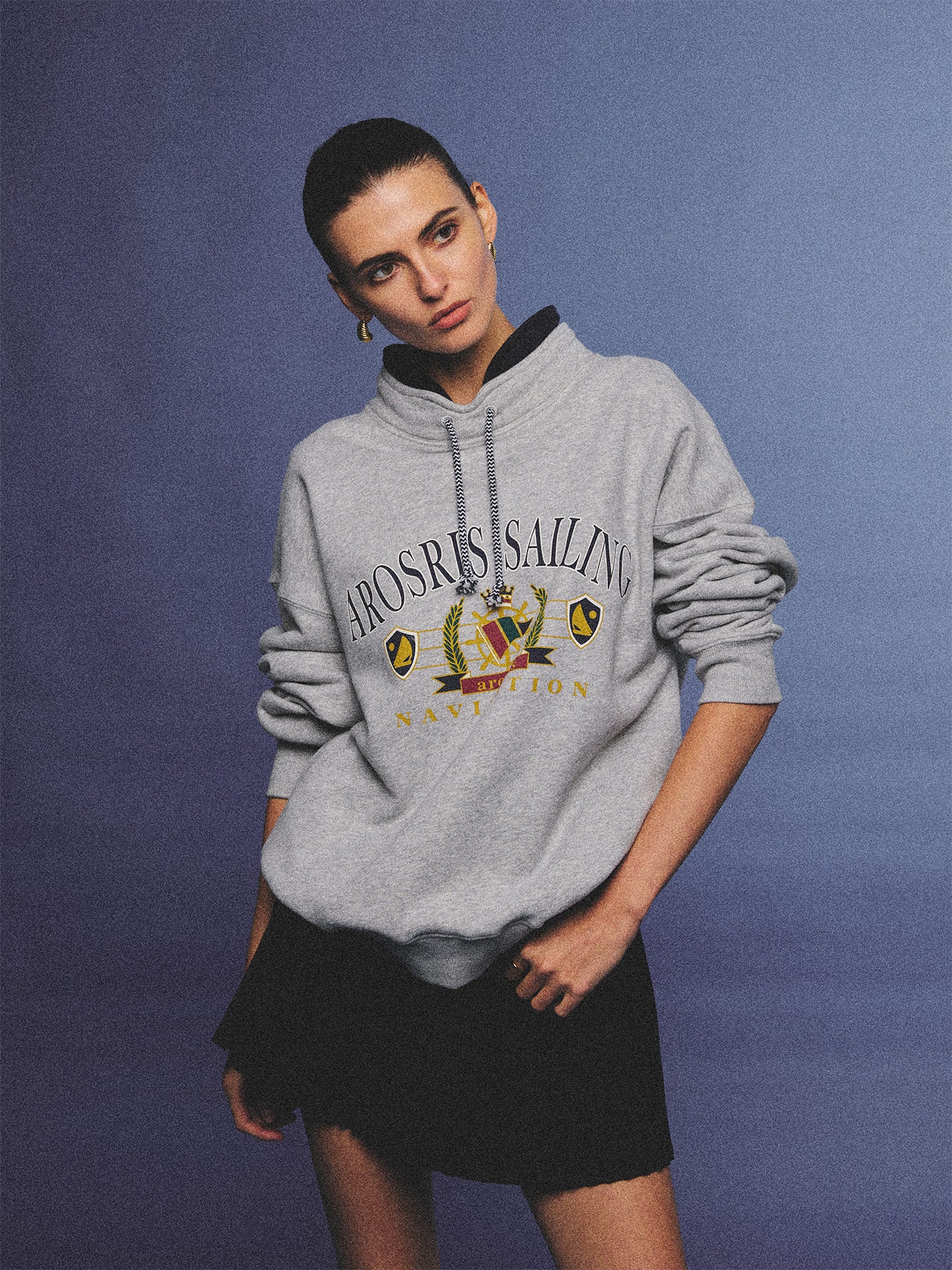 Arosris ash grey sailing navigation mock neck sweatshirt elegantly styled on a model, capturing an effortless 90s sporty-chic coastal yacht club aesthetic.