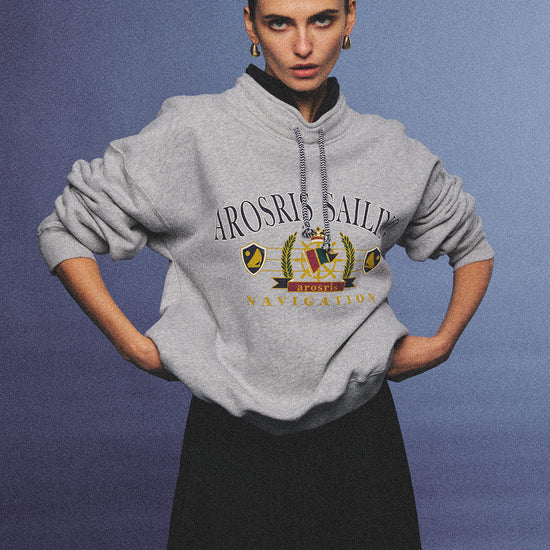 Arosris ash grey sailing navigation mock neck sweatshirt elegantly styled on a model, capturing an effortless 90s sporty-chic coastal yacht club aesthetic.