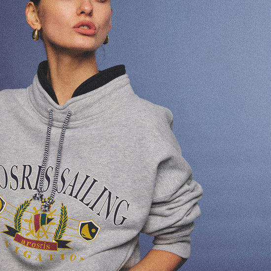 Arosris ash grey sailing navigation mock neck sweatshirt elegantly styled on a model, capturing an effortless 90s sporty-chic coastal yacht club aesthetic.
