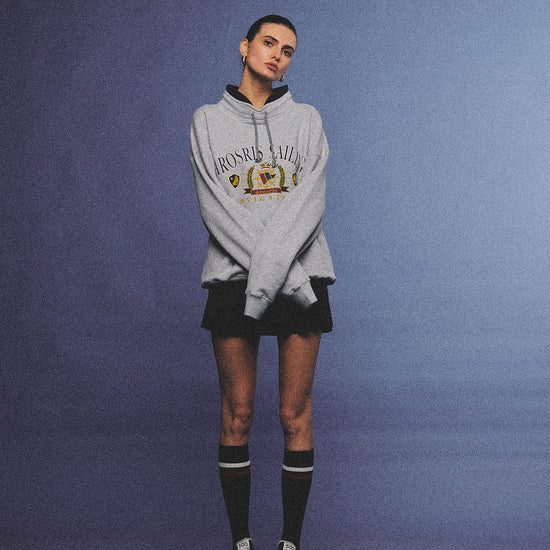 Arosris ash grey sailing navigation mock neck sweatshirt elegantly styled on a model, capturing an effortless 90s sporty-chic coastal yacht club aesthetic.