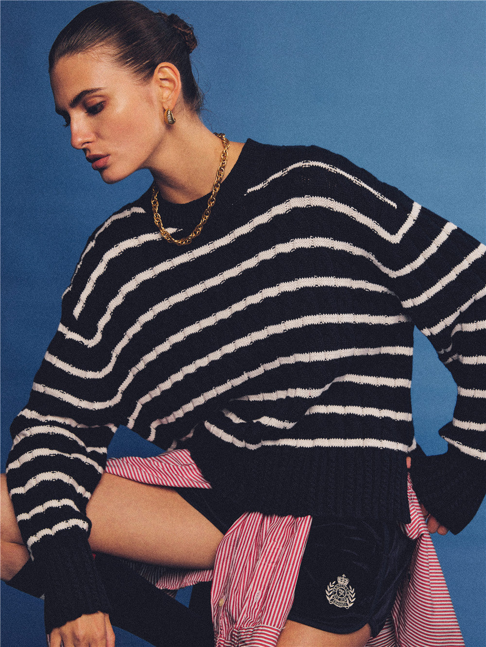 Arosris navy and white nautical striped crewneck sweater, styled with a contrast shirt tied at the waist for an effortless 90s vintage sporty-chic aesthetic.
