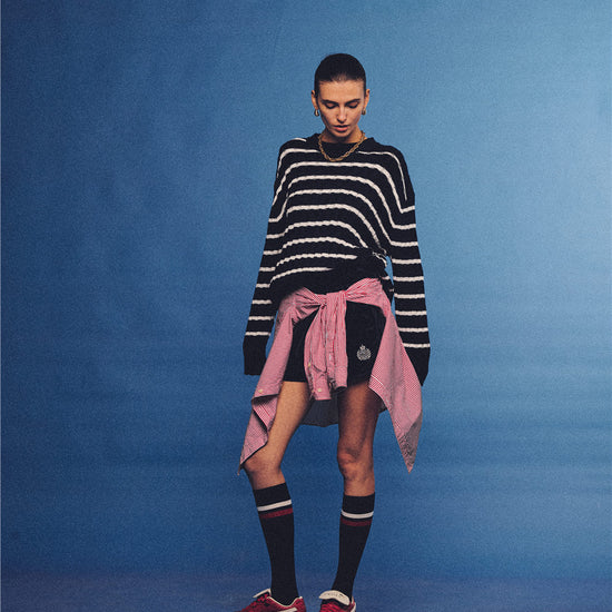 Arosris navy and white nautical striped crewneck sweater, styled with a contrast shirt tied at the waist for an effortless 90s vintage sporty-chic aesthetic.