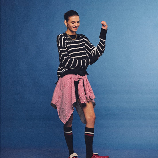 Arosris navy and white nautical striped crewneck sweater, styled with a contrast shirt tied at the waist for an effortless 90s vintage sporty-chic aesthetic.