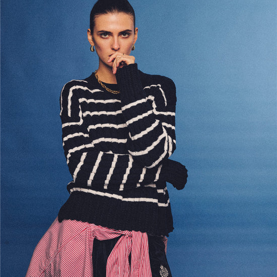 Arosris navy and white nautical striped crewneck sweater, styled with a contrast shirt tied at the waist for an effortless 90s vintage sporty-chic aesthetic.