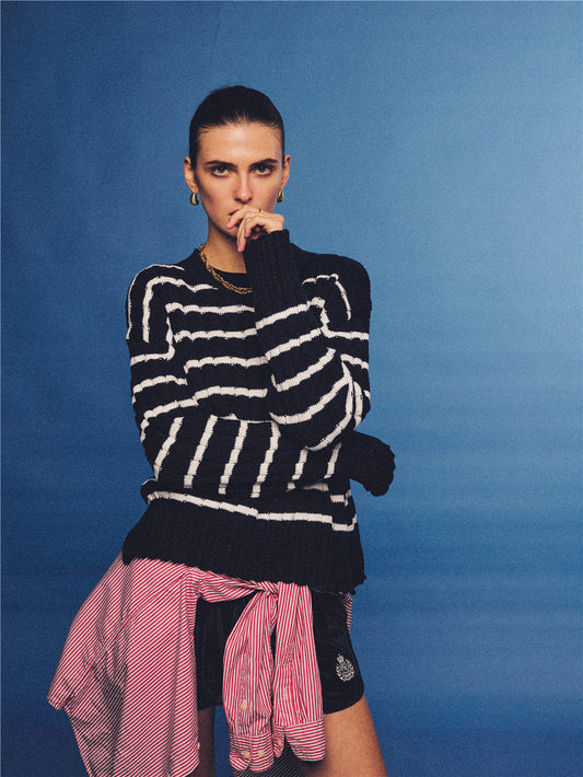 Arosris navy and white nautical striped crewneck sweater, styled with a contrast shirt tied at the waist for an effortless 90s vintage sporty-chic aesthetic.