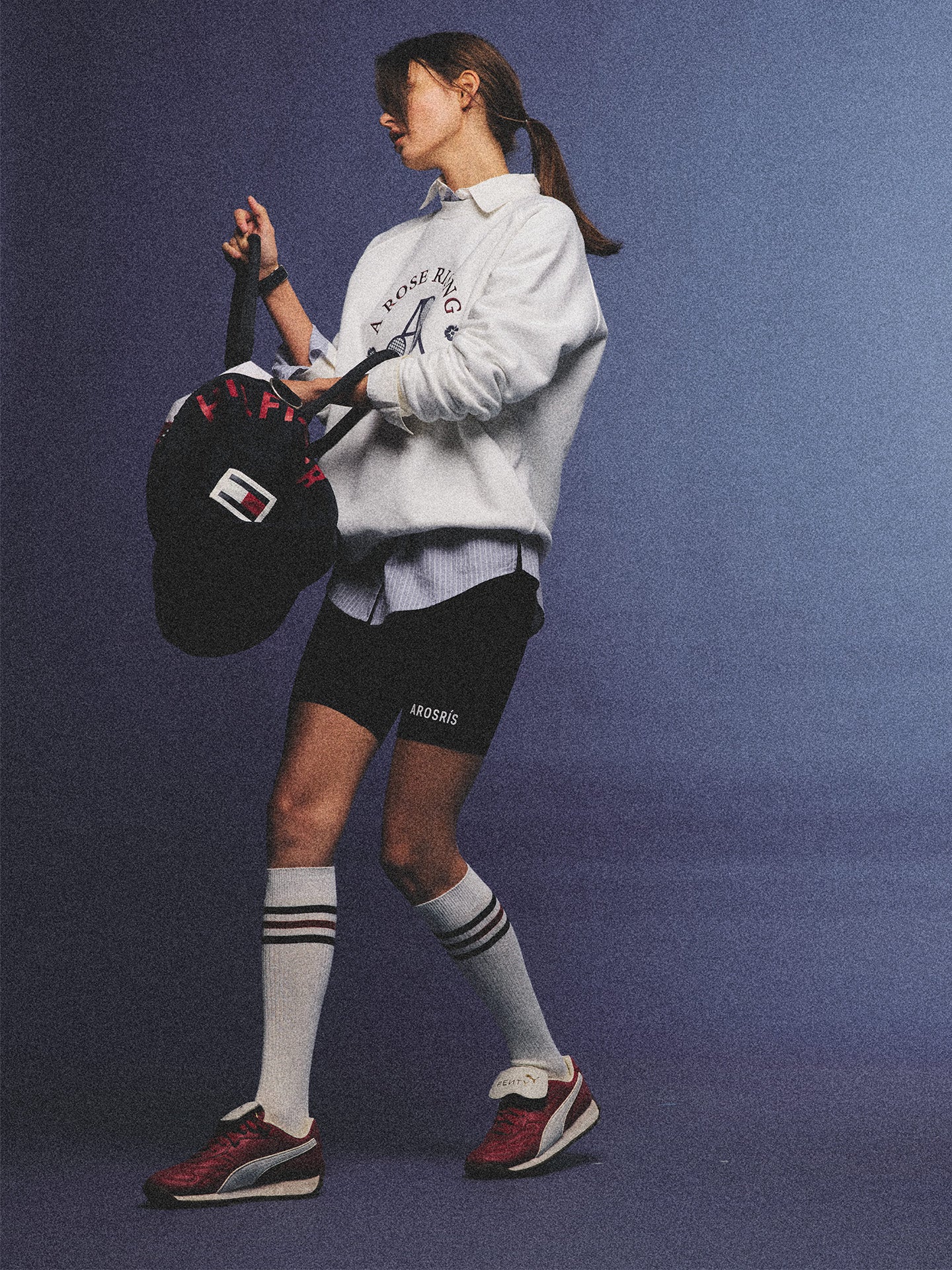 Arosris club white tennis club heritage sweatshirt with vintage crest graphic layered over a crisp collared shirt, elegantly styled on a model for an effortless 90s tenniscore and old money sporty rich aesthetic.