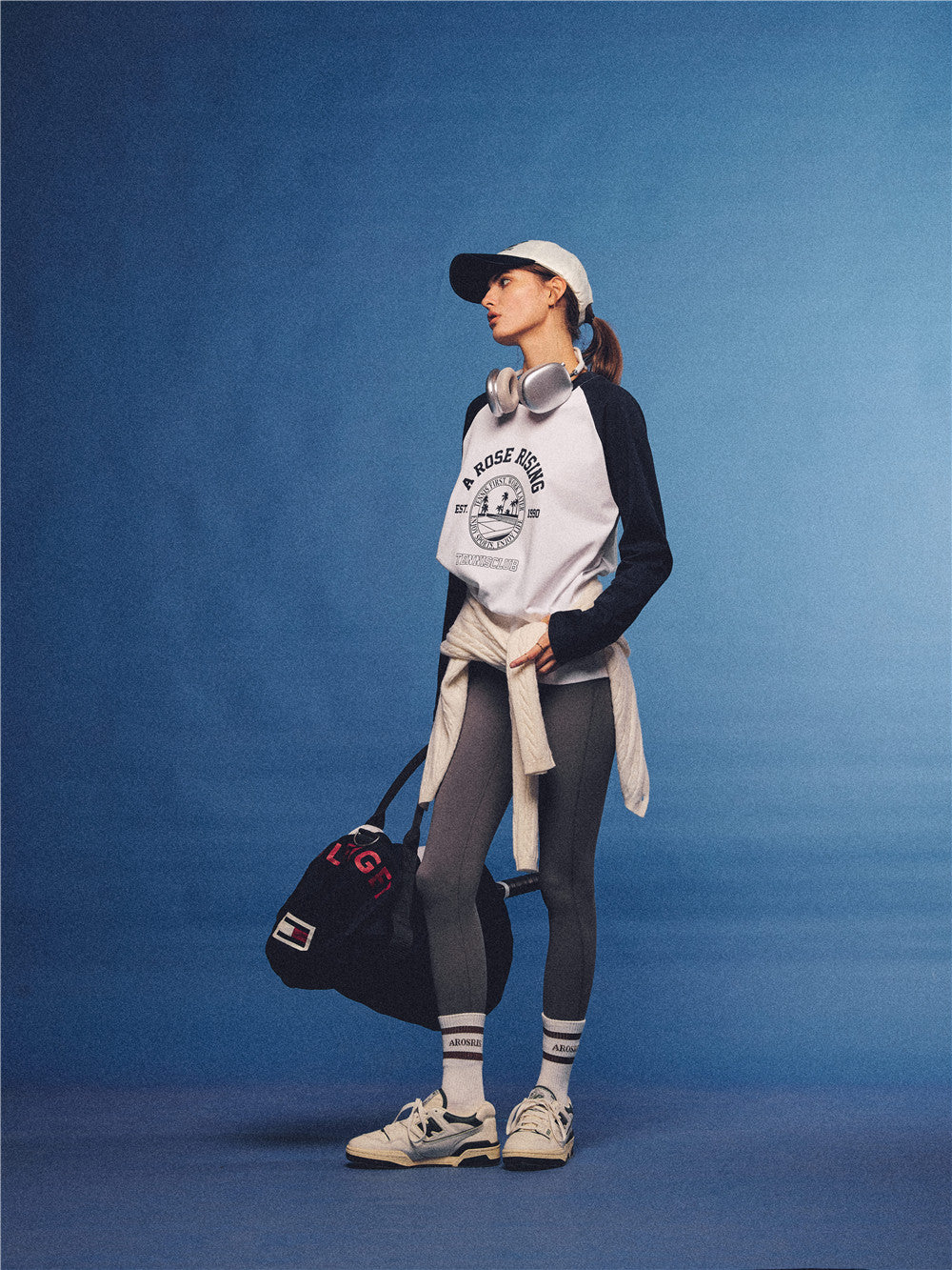 Arosris white and navy raglan long sleeve T-shirt, styled with a tennis skirt and cap for an effortless 90s vintage sporty-rich aesthetic.