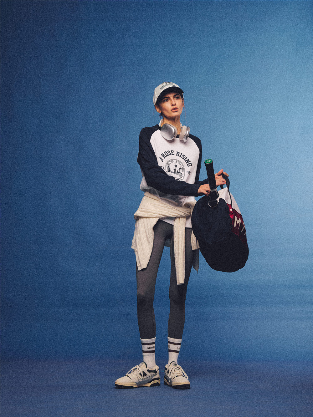 Arosris white and navy raglan long sleeve T-shirt, styled with a tennis skirt and cap for an effortless 90s vintage sporty-rich aesthetic.