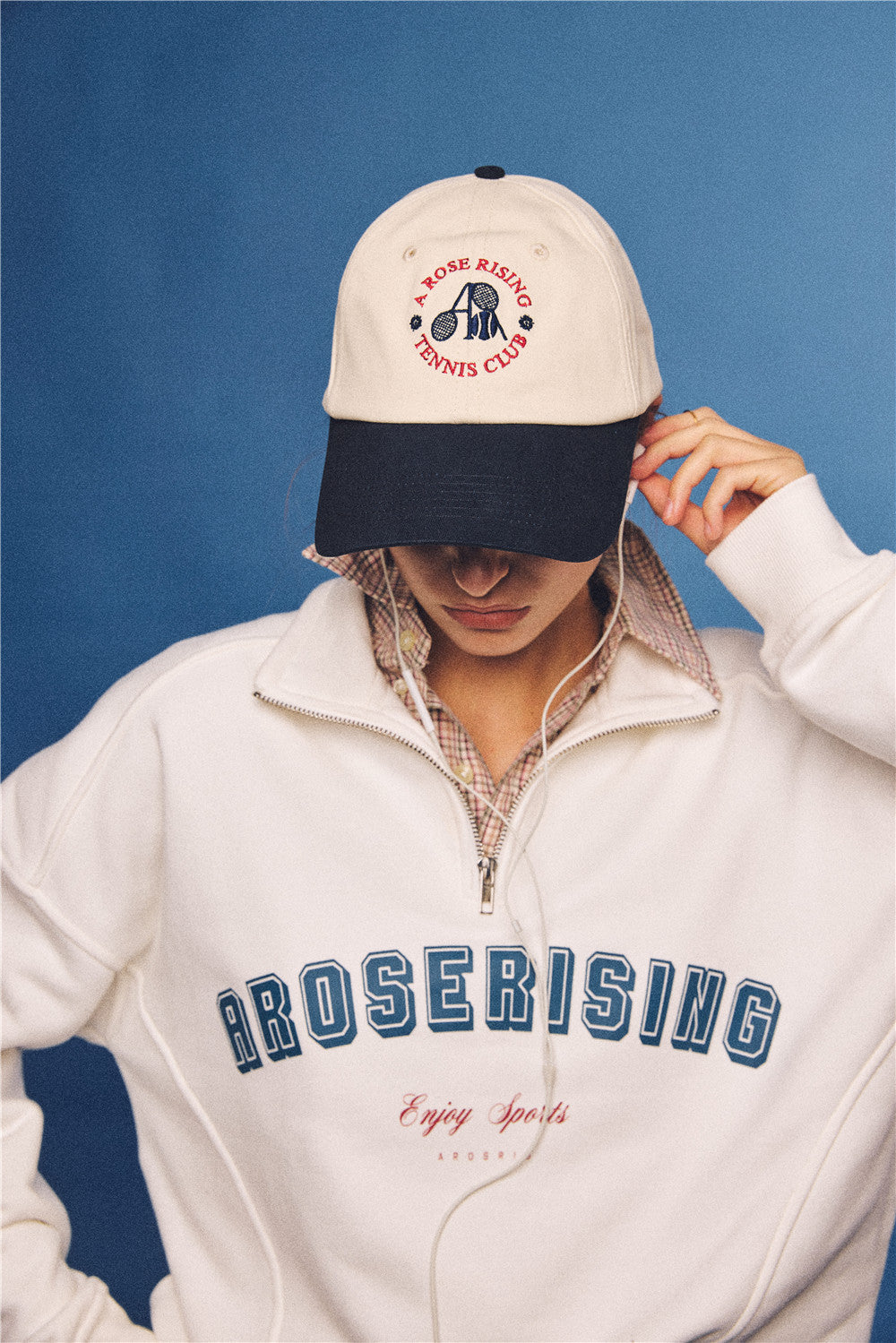 Arosris vintage-inspired two-tone cream and navy tennis club dad hat, styled with a retro half-zip sweatshirt for an effortless 90s sporty-rich aesthetic.