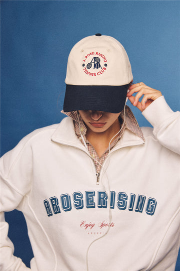Arosris vintage-inspired two-tone cream and navy tennis club dad hat, styled with a retro half-zip sweatshirt for an effortless 90s sporty-rich aesthetic.