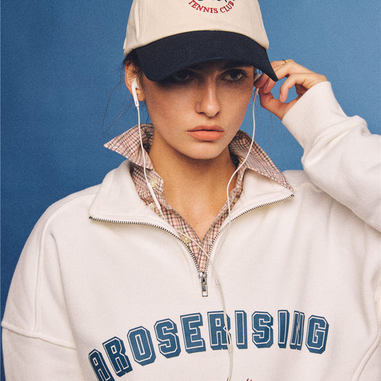 Arosris vintage-inspired two-tone cream and navy tennis club dad hat, styled with a retro half-zip sweatshirt for an effortless 90s sporty-rich aesthetic.