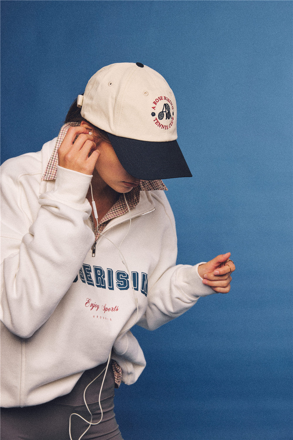 Arosris vintage-inspired two-tone cream and navy tennis club dad hat, styled with a retro half-zip sweatshirt for an effortless 90s sporty-rich aesthetic.