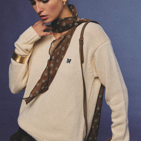 Arosris creamy khaki v-neck embroidered sweater, elegantly styled with a vintage silk scarf and plaid skirt for an effortless 90s old money aesthetic.
