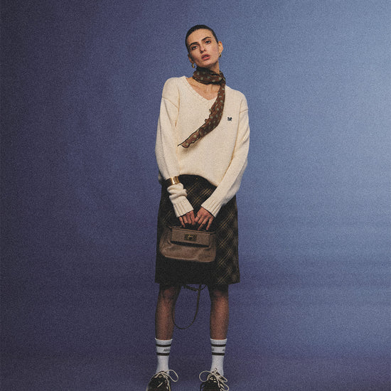 Arosris creamy khaki v-neck embroidered sweater, elegantly styled with a vintage silk scarf and plaid skirt for an effortless 90s old money aesthetic.